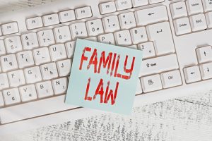 Conceptual hand writing showing Family Law. Business photo showcasing body of legal practice dealing with inside household matters Keyboard office supplies rectangle shape paper reminder wood.