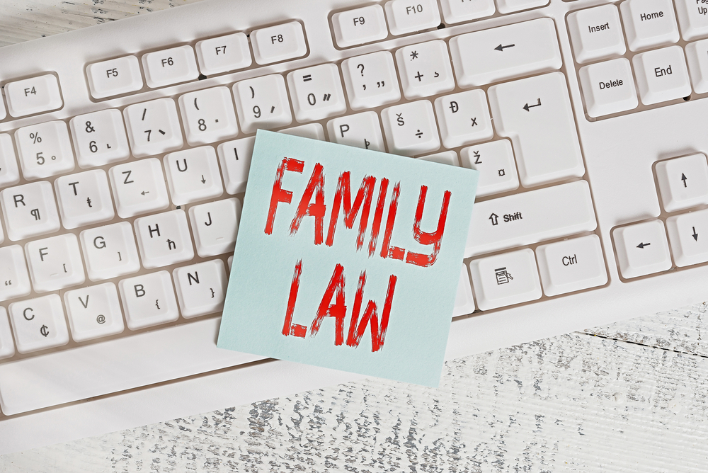 Family Law written in sticky note on top of keyboard